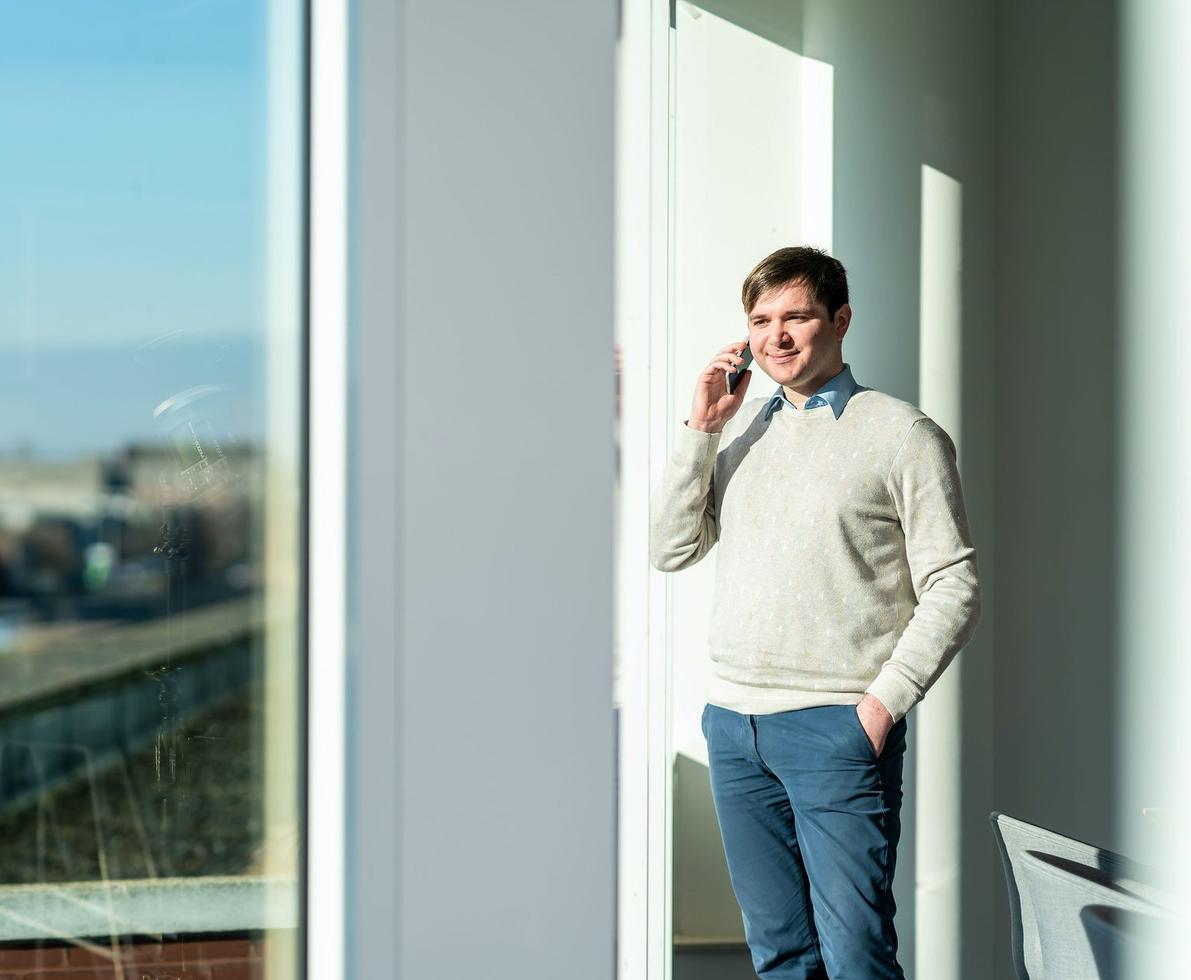 Man making a phone call by the window.